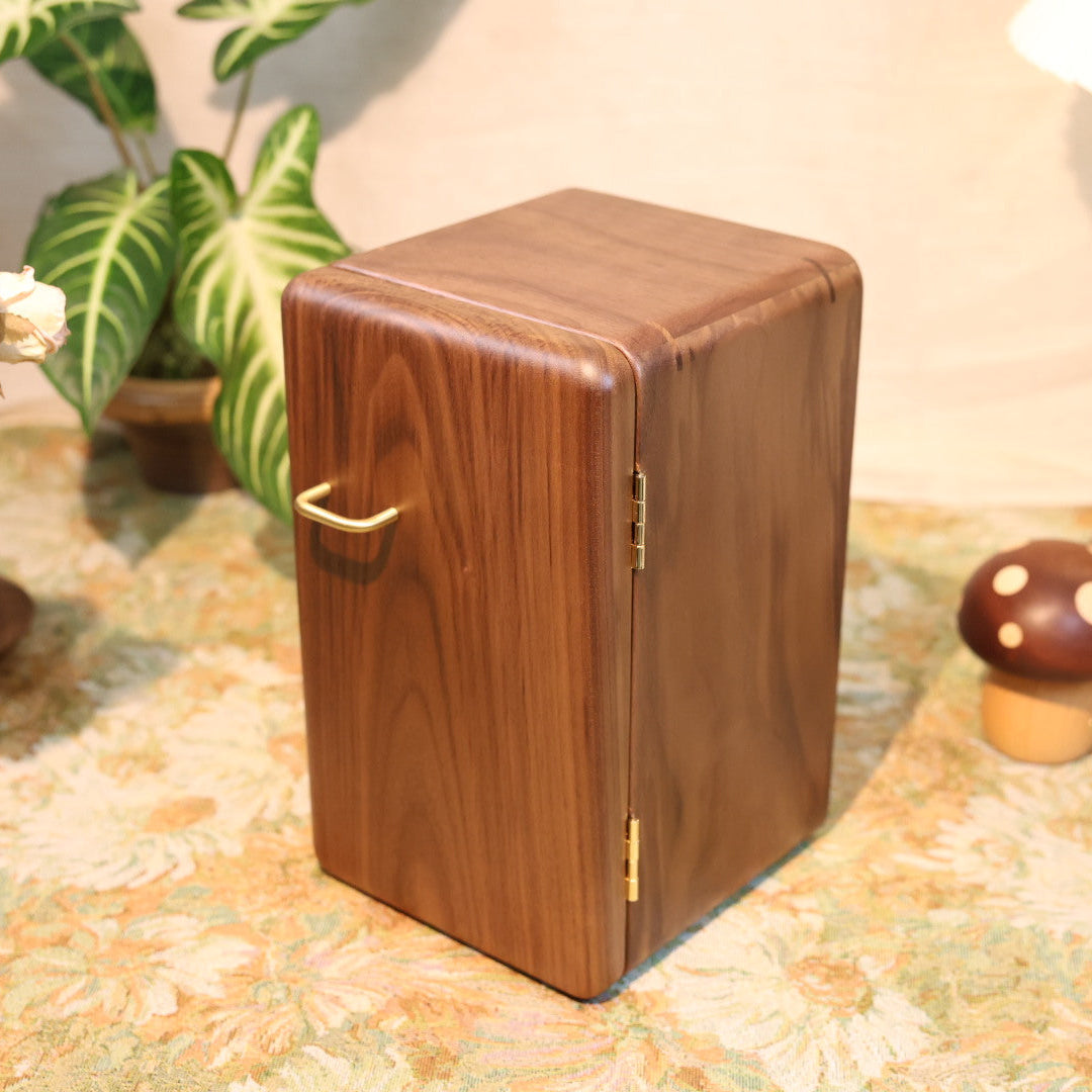 Wooden casket on a decorative surface with plants and candles in the background