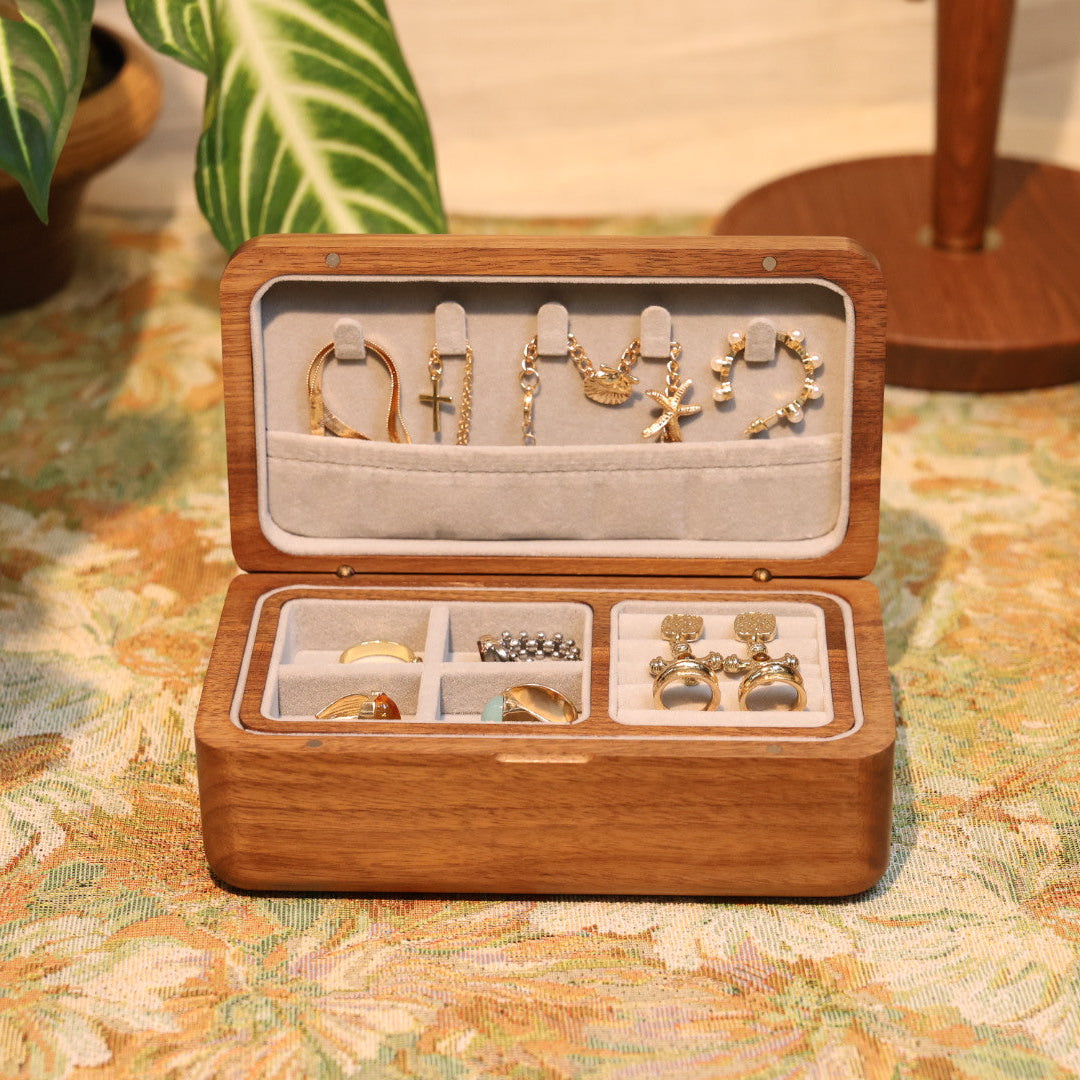 Wooden jewelry box with gold earrings on a patterned surface