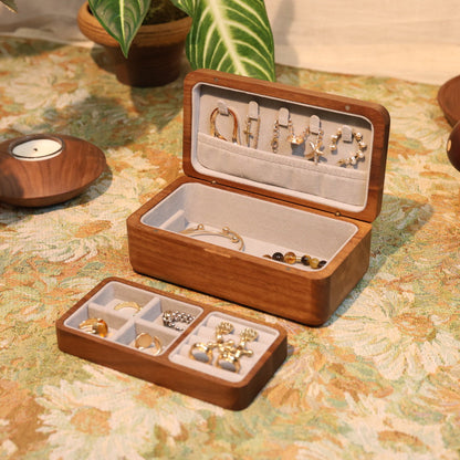Wooden jewelry box with earrings on a floral tablecloth
