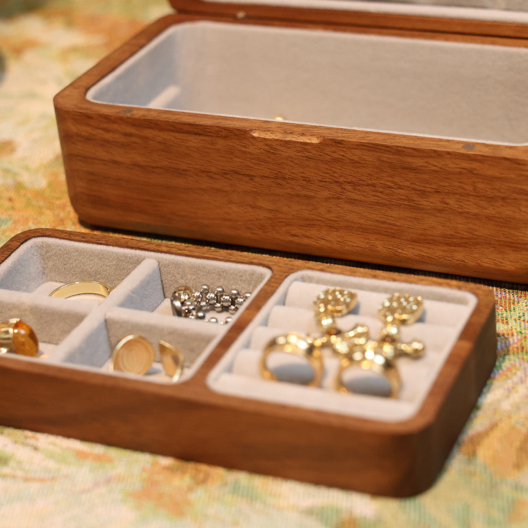 Wooden jewelry box with gold earrings on a patterned surface