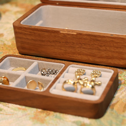 Wooden jewelry box with gold earrings on a patterned surface