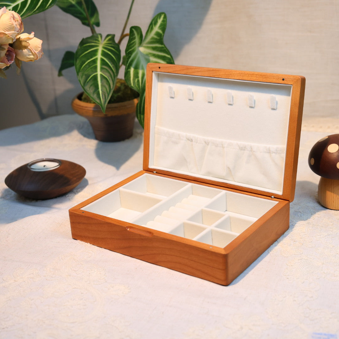 Wooden jewelry box with earrings on a textured surface with decorative items.