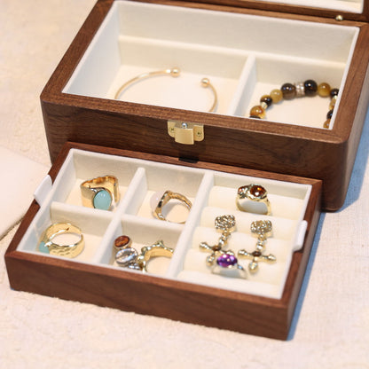 Wooden jewelry box with jewelry displayed on a light background