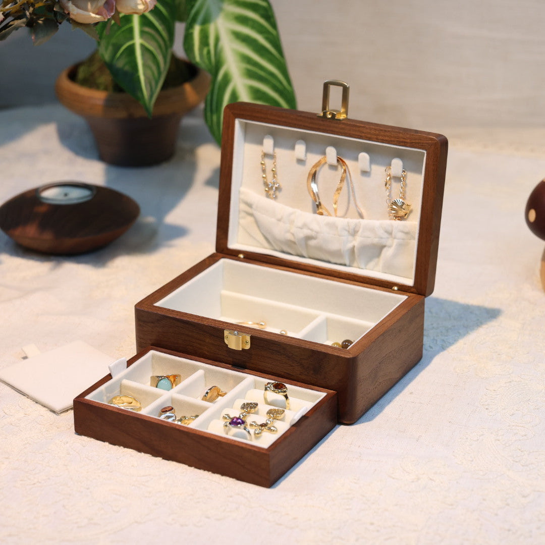 Wooden jewelry box with jewelry on a soft surface with plants in the background