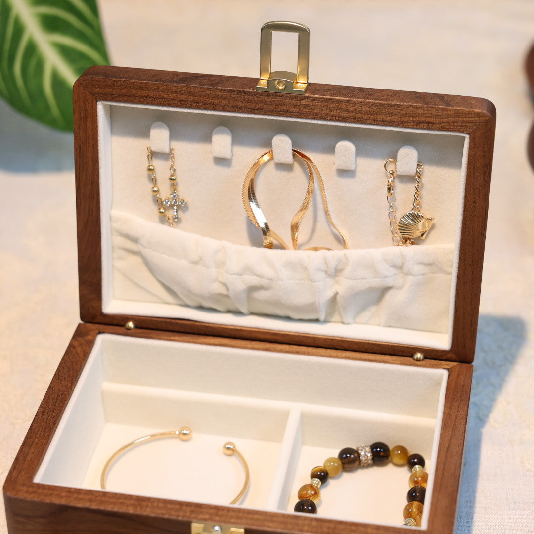 Wooden jewelry box with gold and black bracelets inside