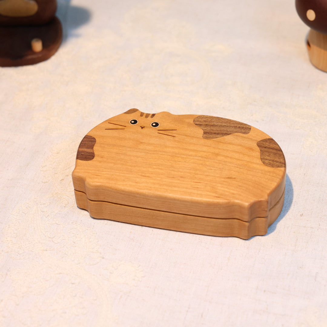 Wooden cat-shaped box on a textured surface
