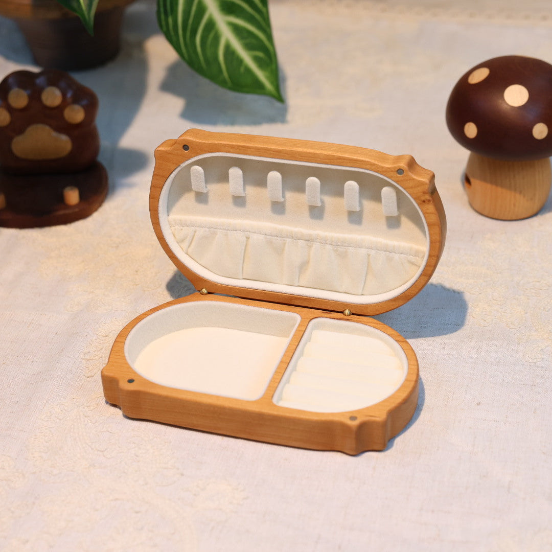Wooden fishing lure box with open lid on a light surface with decorative items.