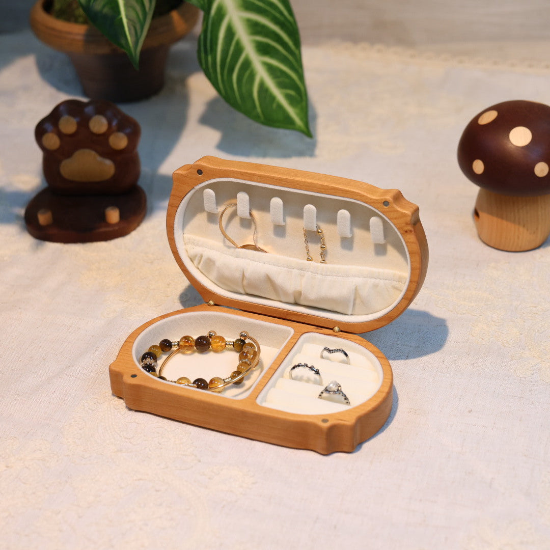 Wooden jewelry box with necklaces on a light surface with decorative items around