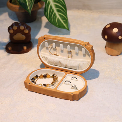 Wooden jewelry box with necklaces on a light surface with decorative items around