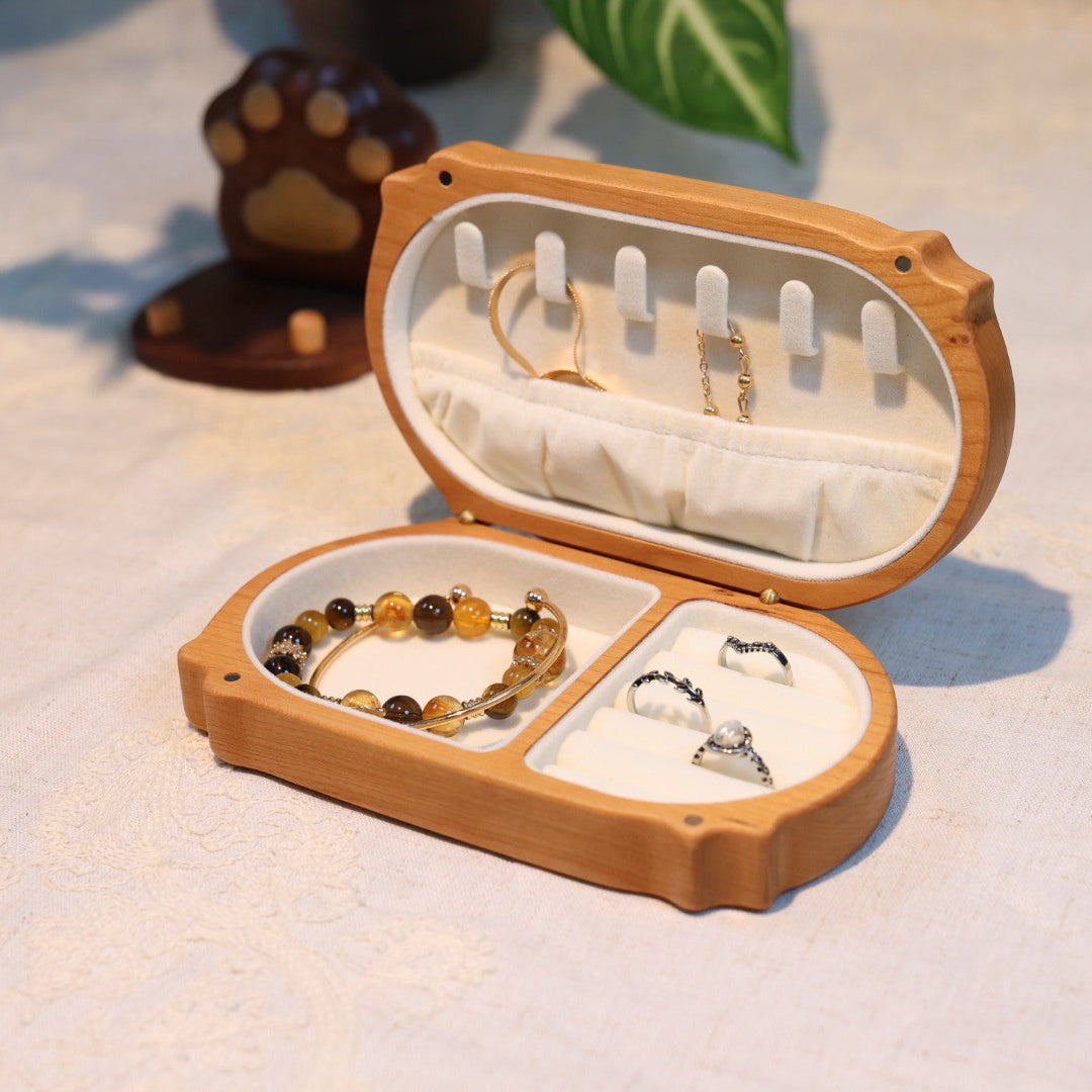 Open wooden jewelry box with jewelry on a light background