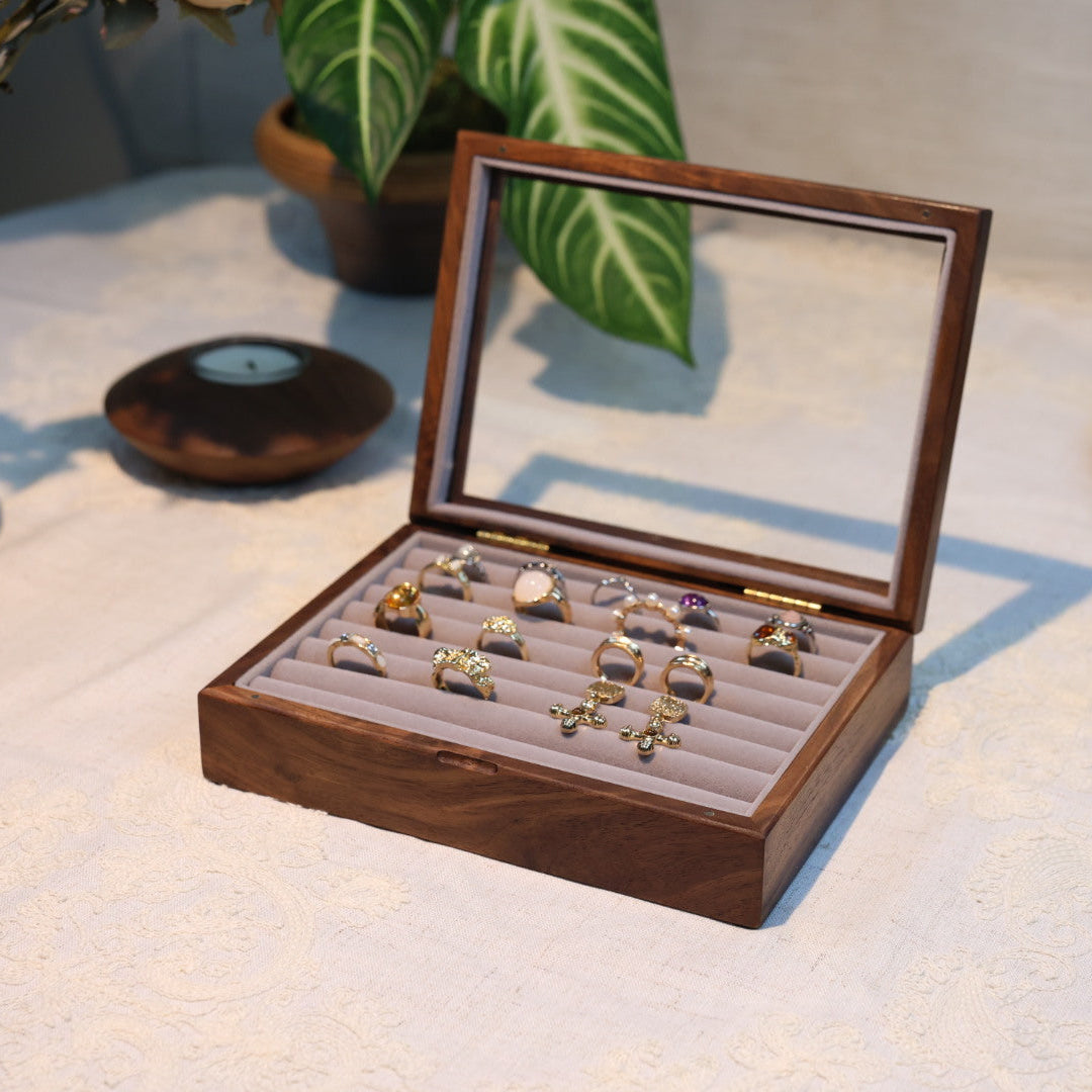 Wooden jewelry box with rings on a textured surface