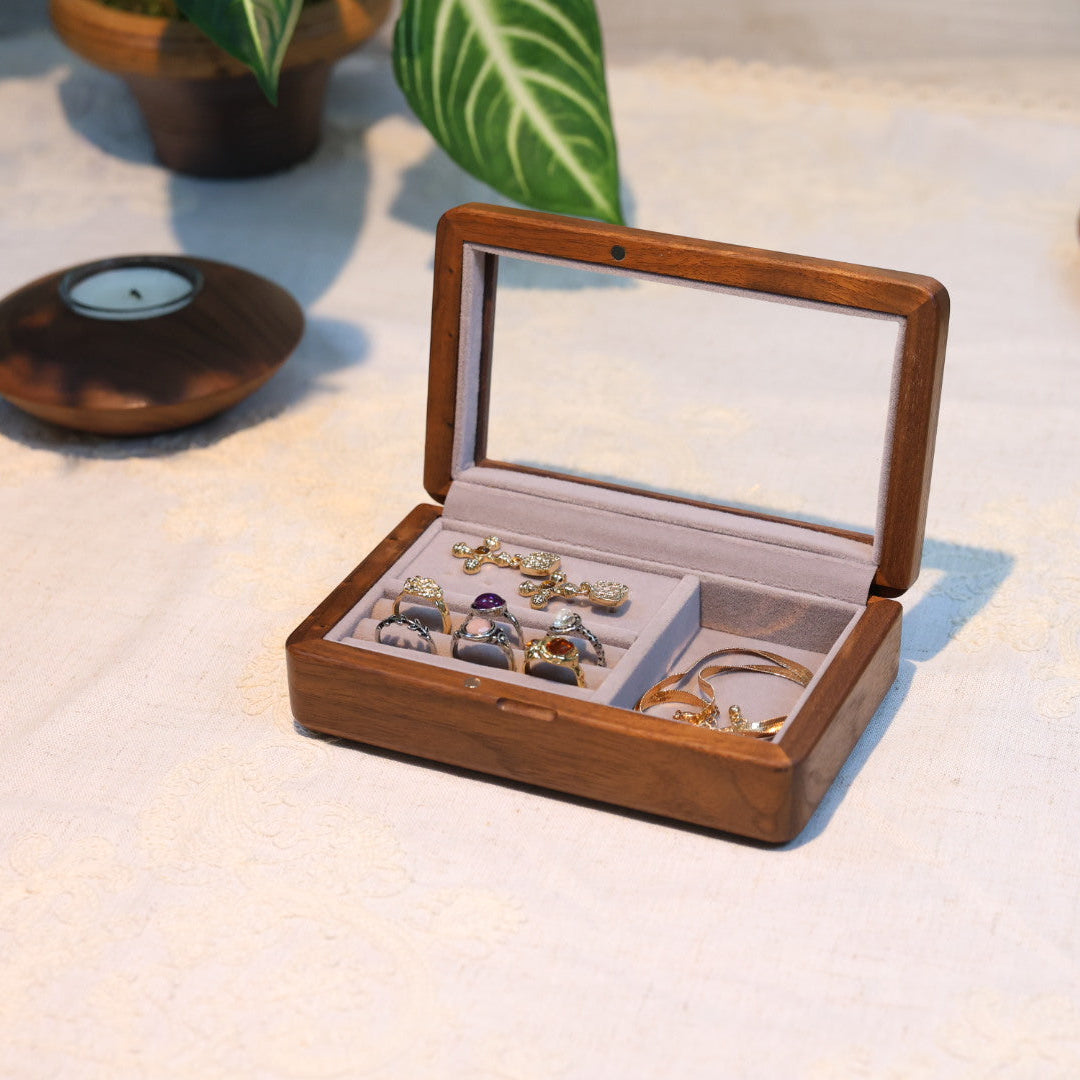 Wooden jewelry box with jewelry on a light surface