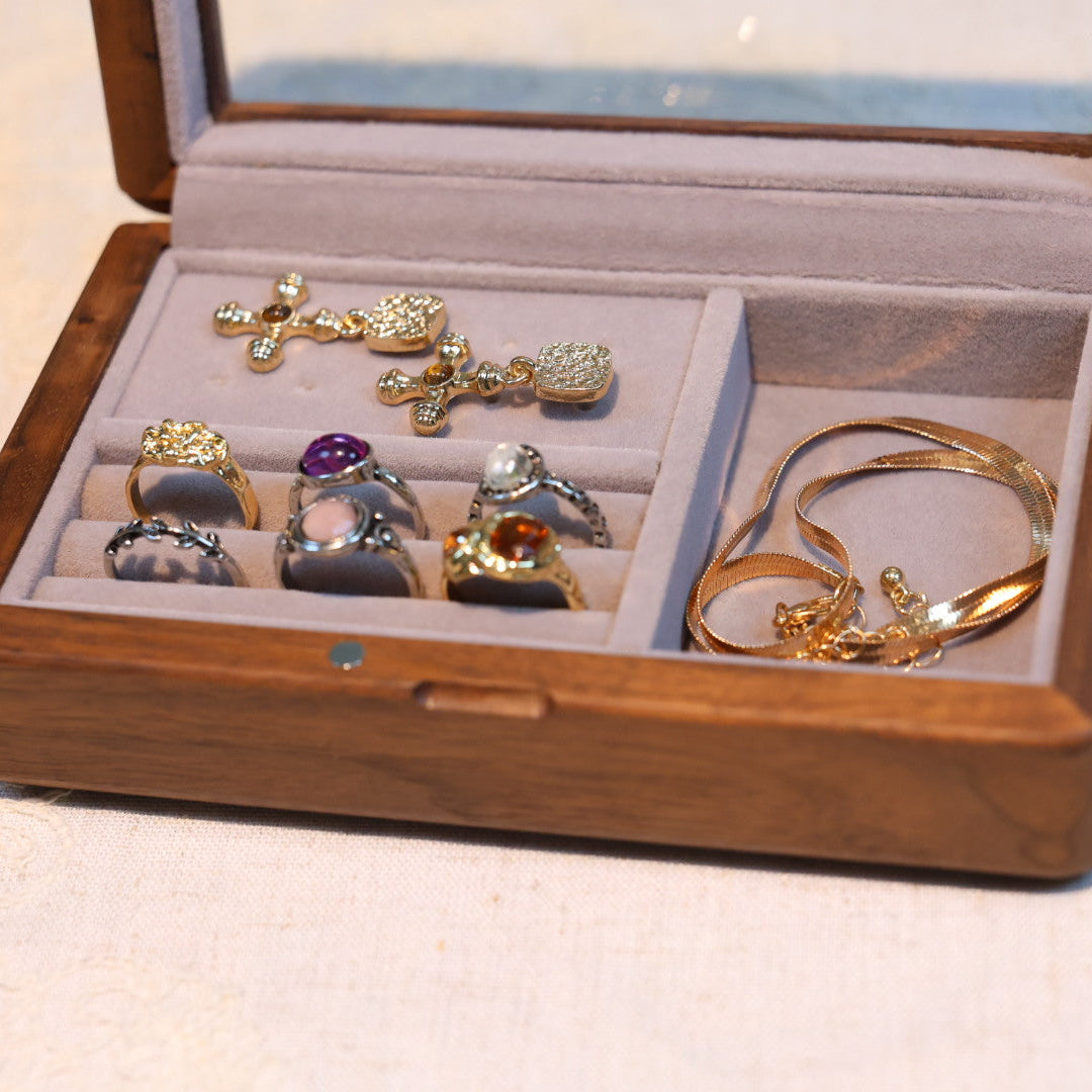Jewelry set including rings and a bracelet in an open wooden jewelry box.