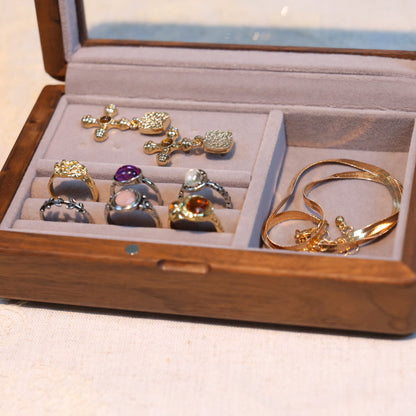 Jewelry set including rings and a bracelet in an open wooden jewelry box.