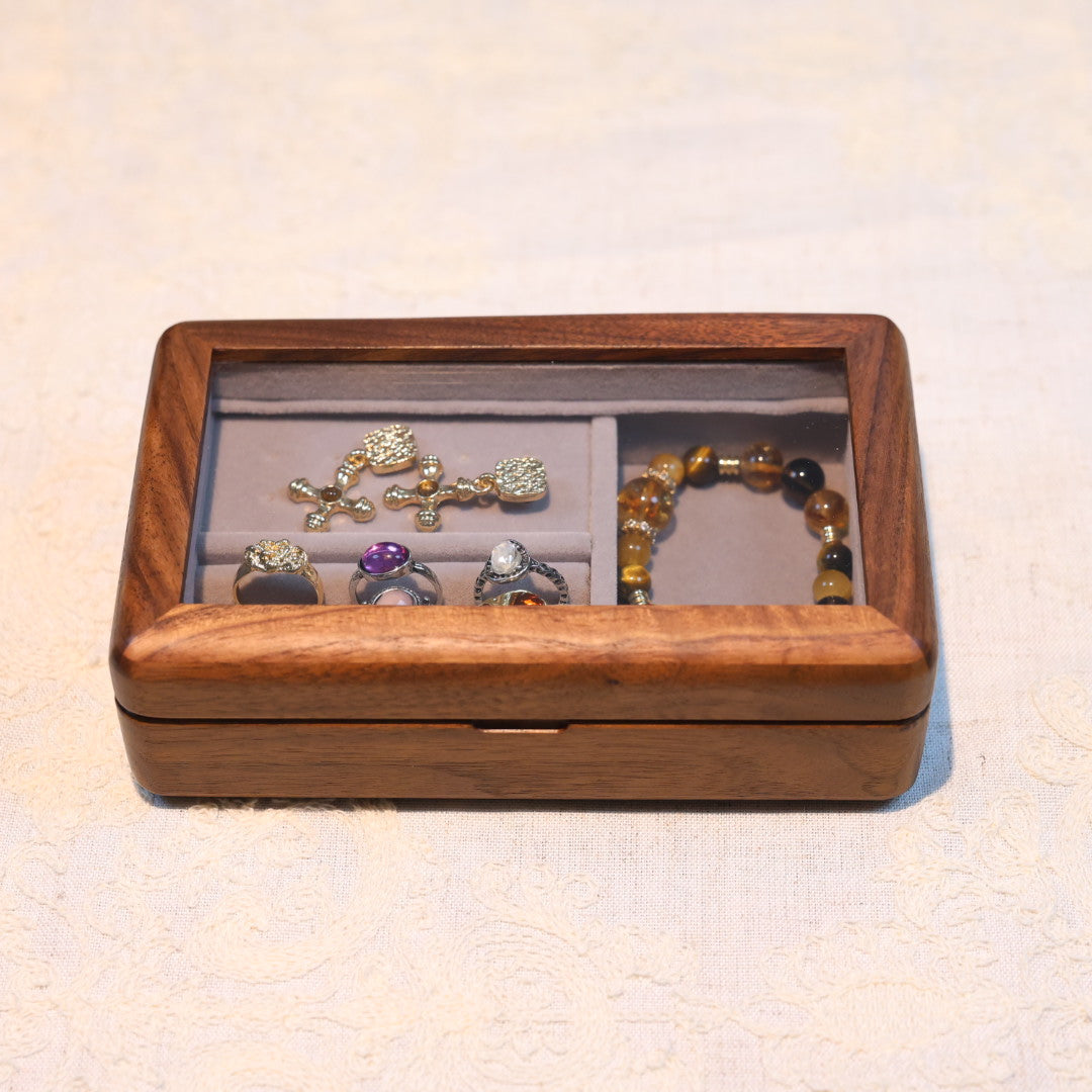Wooden jewelry box with earrings and a bracelet on a light background
