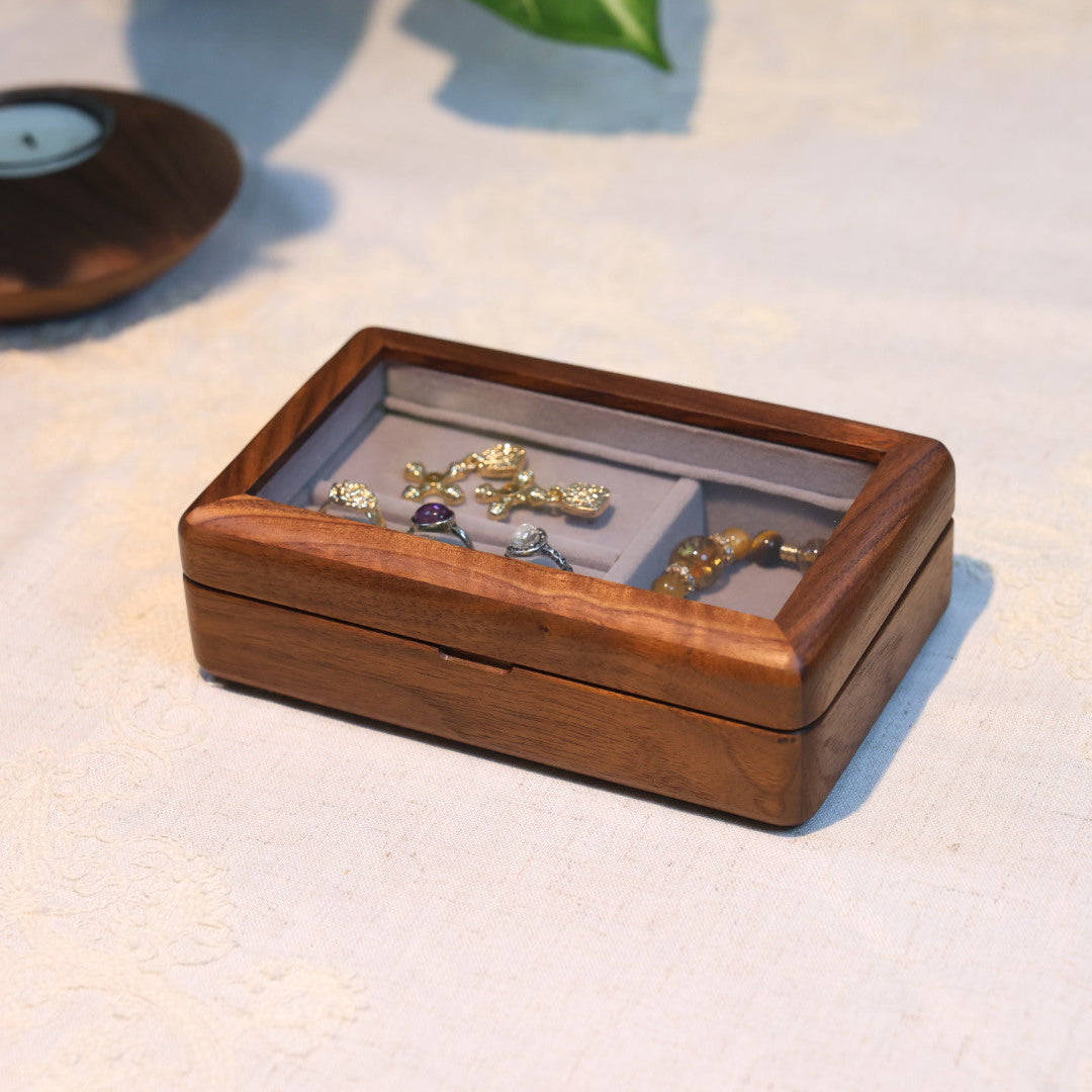 Wooden jewelry box with jewelry on a light surface