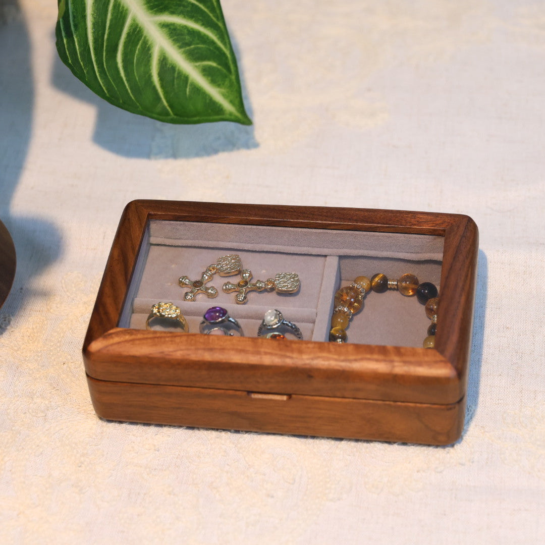 Wooden jewelry box with jewelry on a textured surface