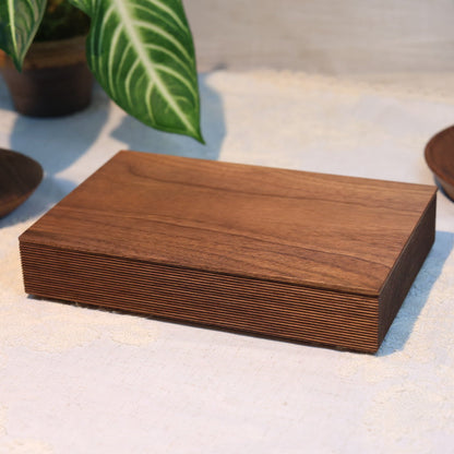 Wooden box on a textured surface with decorative items in the background