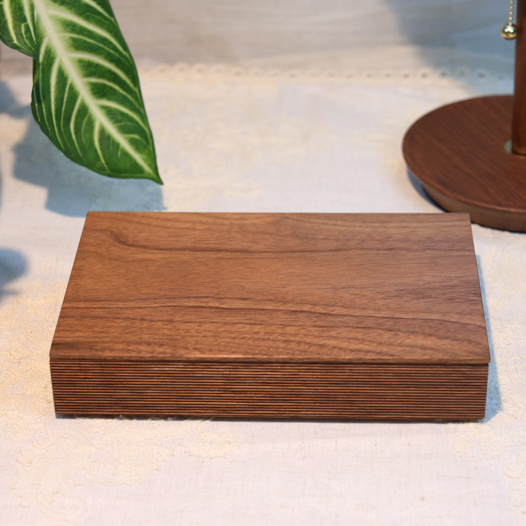 Wooden box on a white surface with decorative items in the background