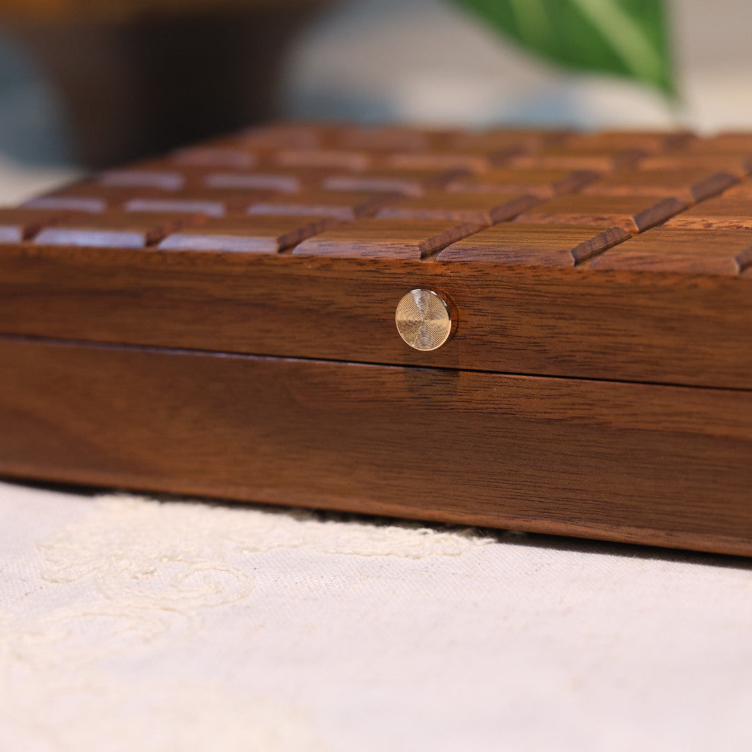 Wooden jewelry box with a metallic clasp on a white surface