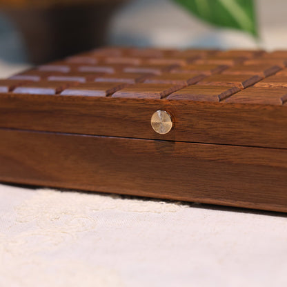 Wooden jewelry box with a metallic clasp on a white surface