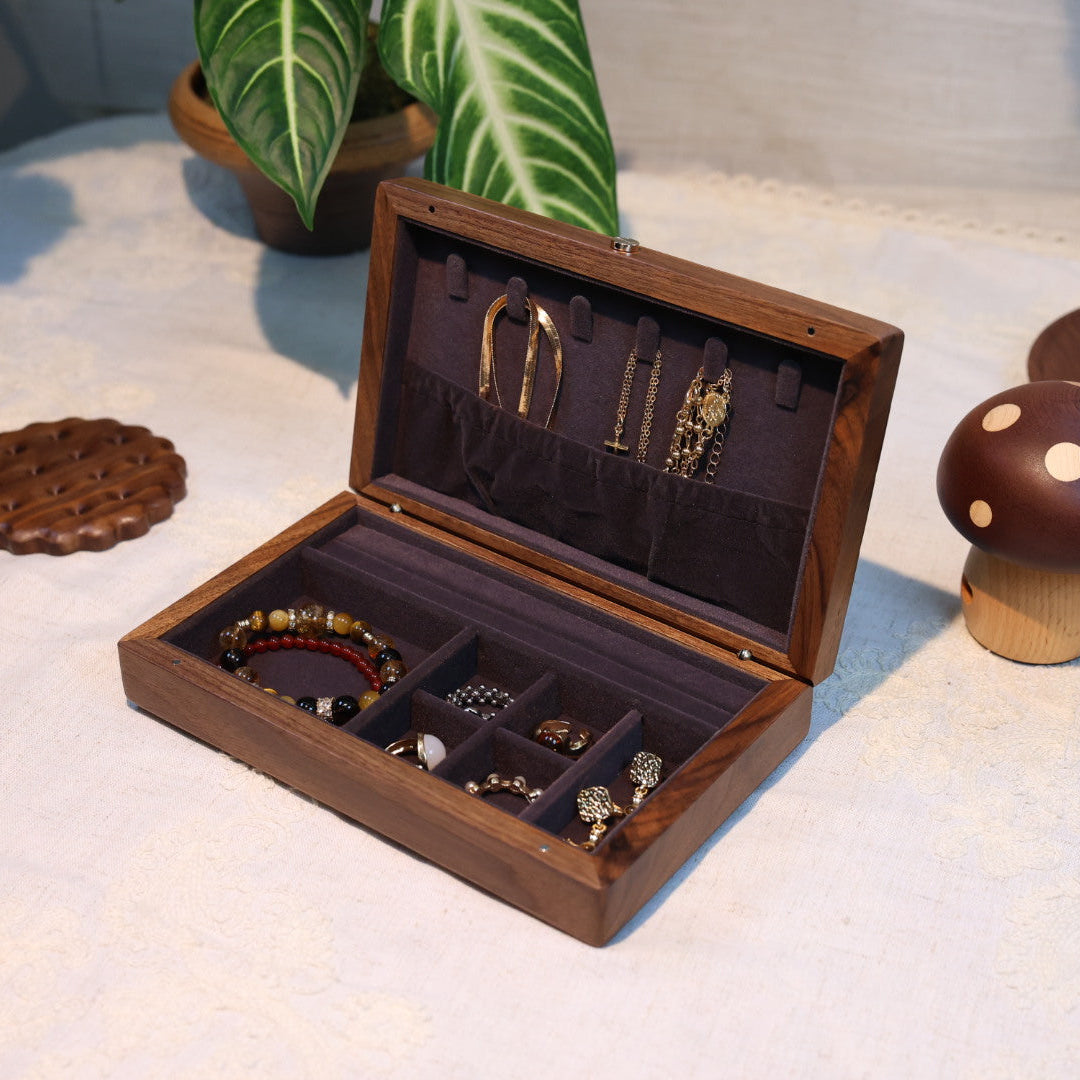 Wooden jewelry box with jewelry on a light surface with decorative items around