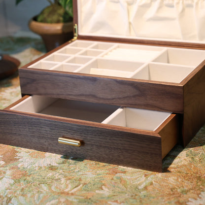 Wooden jewelry box with open lid and drawer on a patterned surface