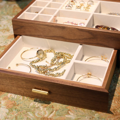 Wooden jewelry box with gold jewelry on a patterned surface