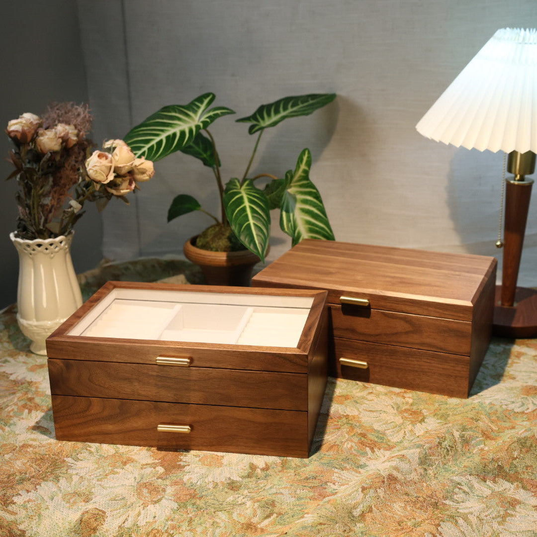 Wooden jewelry box on a patterned surface with a lamp and plant in the background