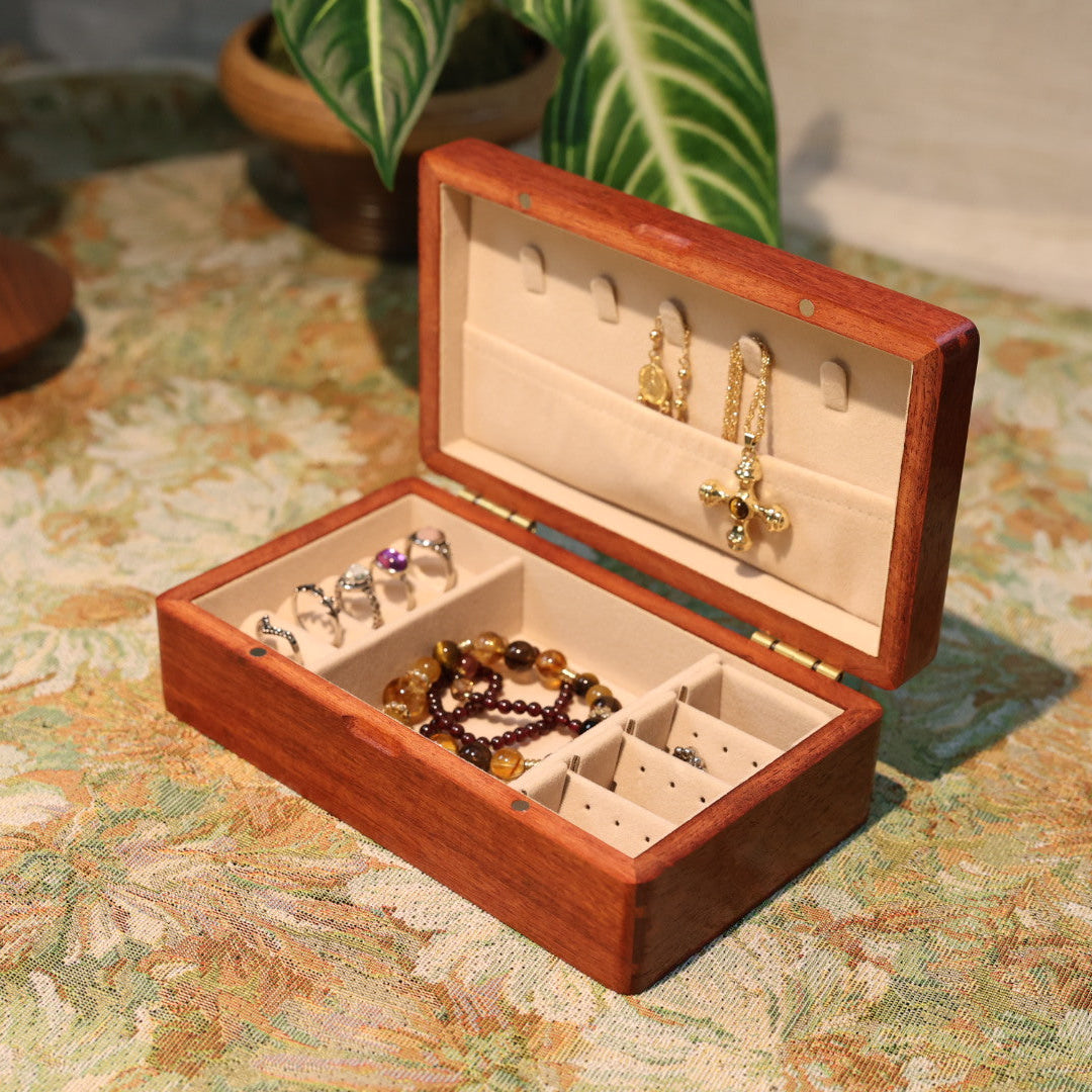 Wooden jewelry box with jewelry on a patterned surface