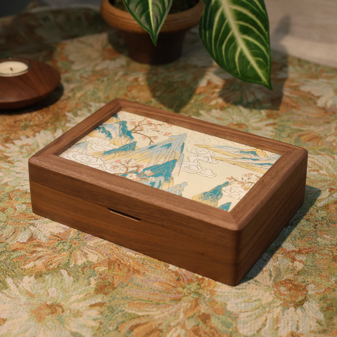 Wooden jewelry box with mosaic design on a floral-patterned tablecloth