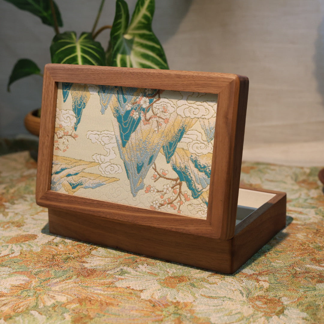 Wooden picture frame with a decorative piece on a floral tablecloth