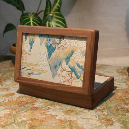 Wooden picture frame with a decorative piece on a floral tablecloth