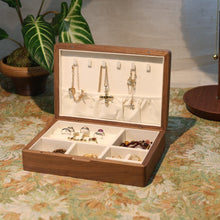 Wooden jewelry box with jewelry on a patterned surface