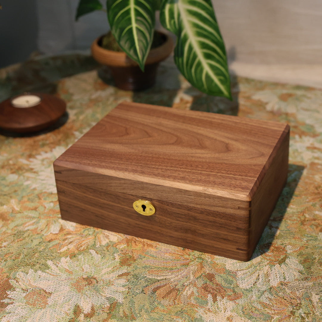 Wooden box with a lock on a patterned surface with plants in the background