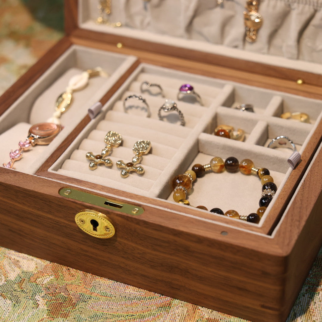 Wooden jewelry box with compartments filled with jewelry on a patterned surface