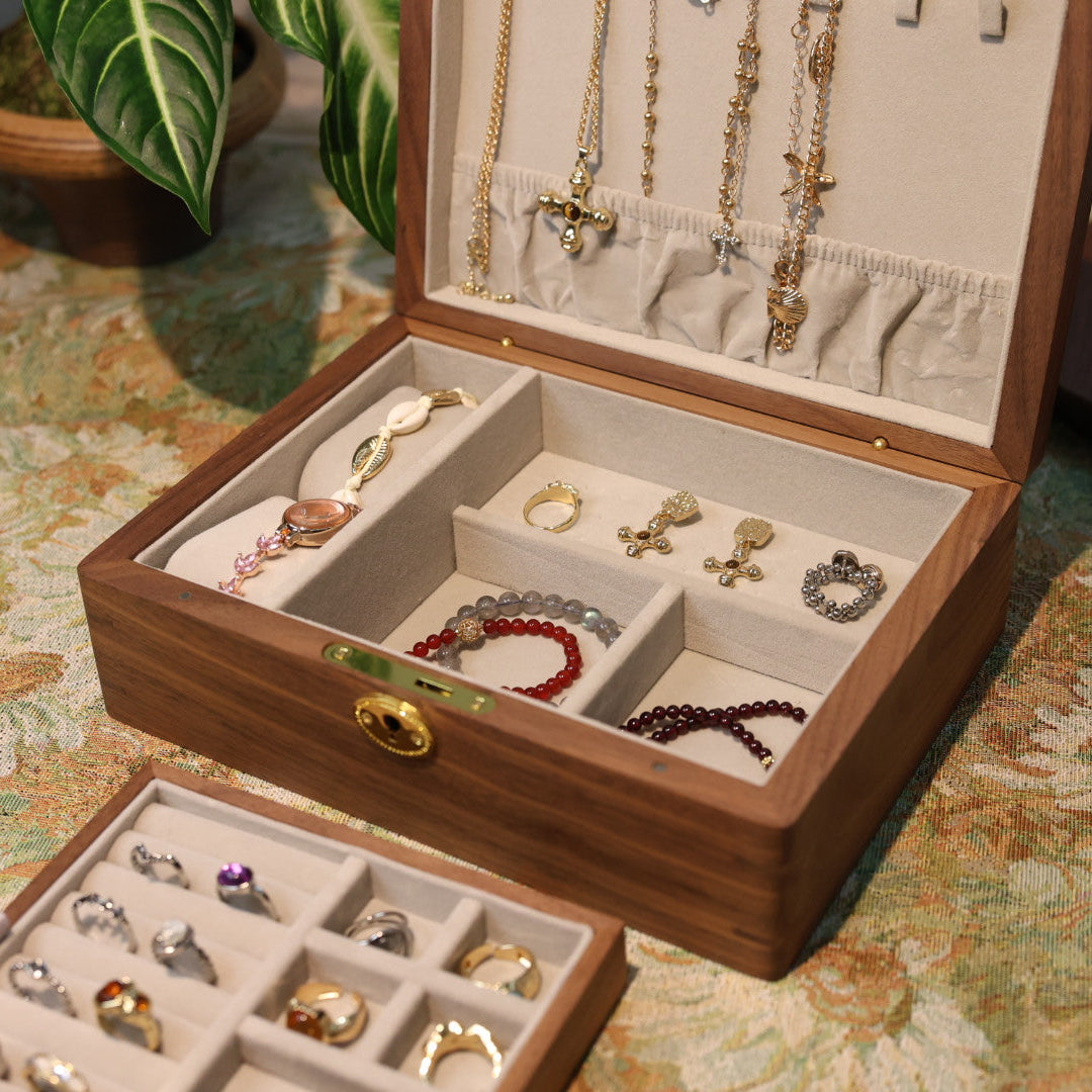 Wooden jewelry box with necklaces, earrings, and bracelets on a patterned surface