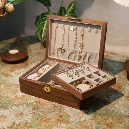 Wooden jewelry box with jewelry on a patterned tablecloth