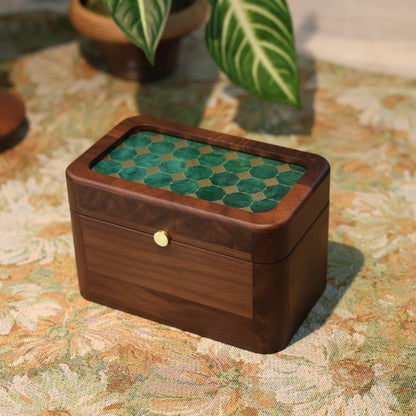 Wooden box with green patterned top on a floral tablecloth