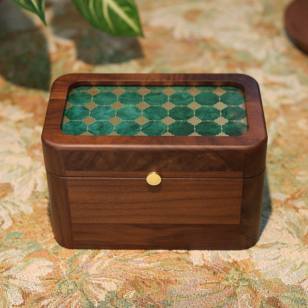 Wooden box with green patterned lid on a floral tablecloth