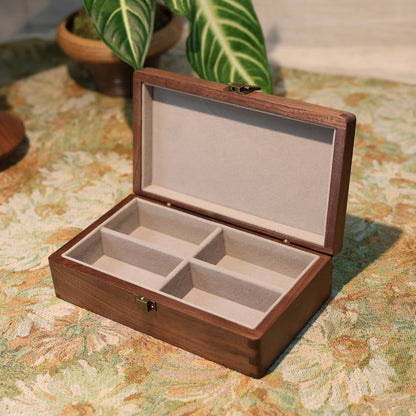 Wooden jewelry box with compartments on a patterned surface