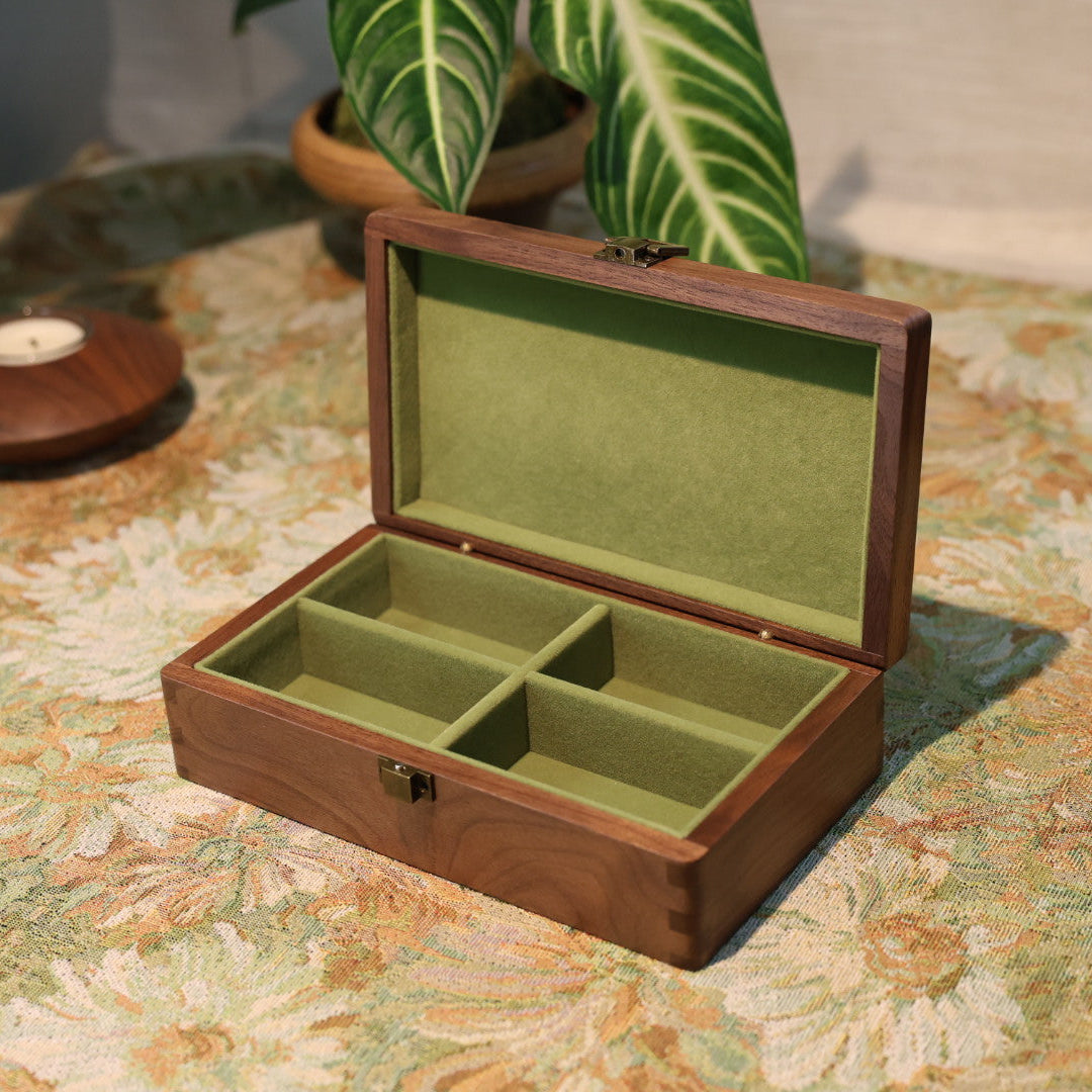Wooden jewelry box with green interior on a patterned surface