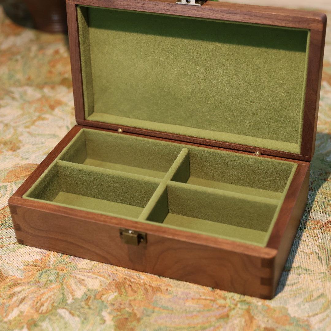Wooden jewelry box with green interior on a floral-patterned surface