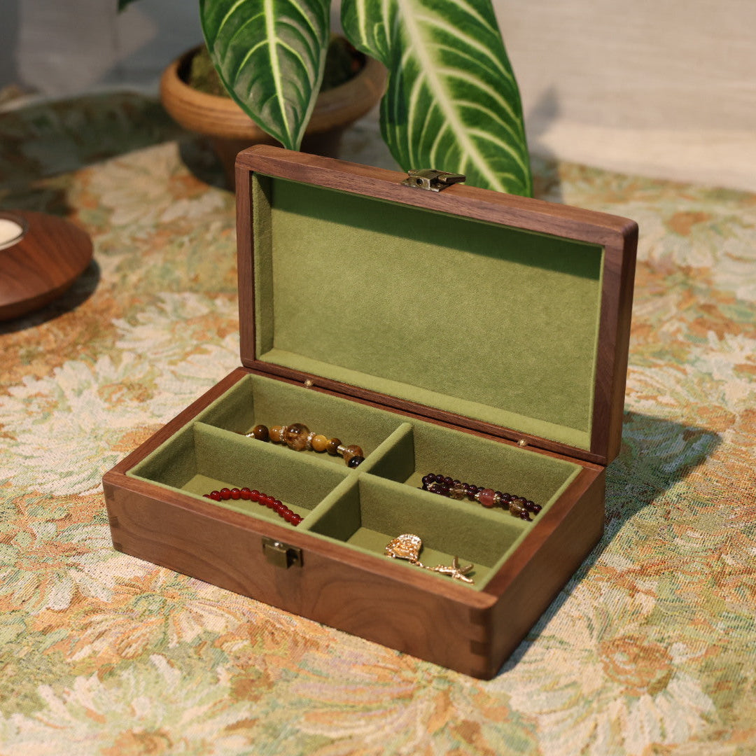 Wooden jewelry box with green interior on a patterned surface