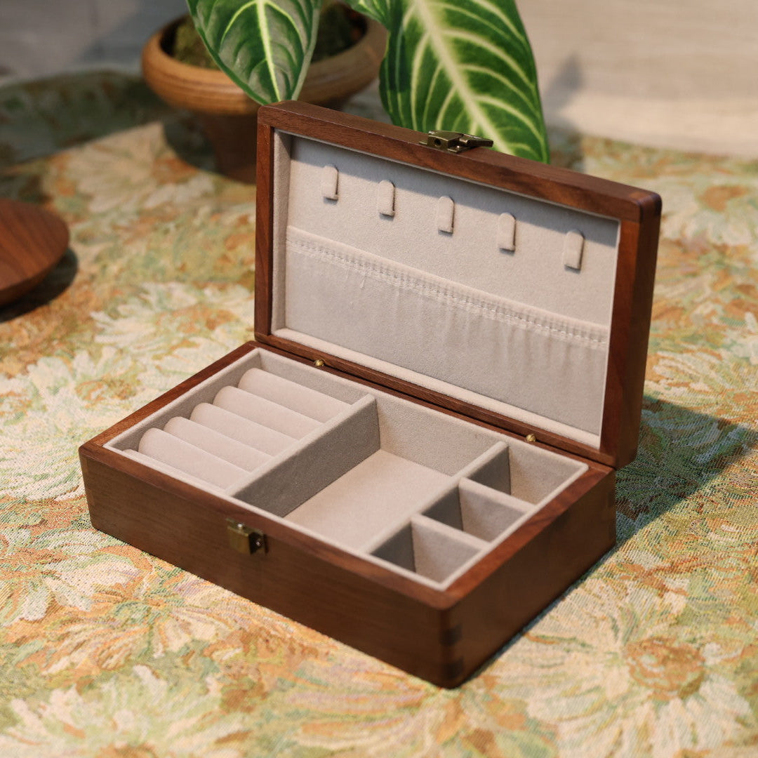 Wooden jewelry box with compartments on a patterned surface