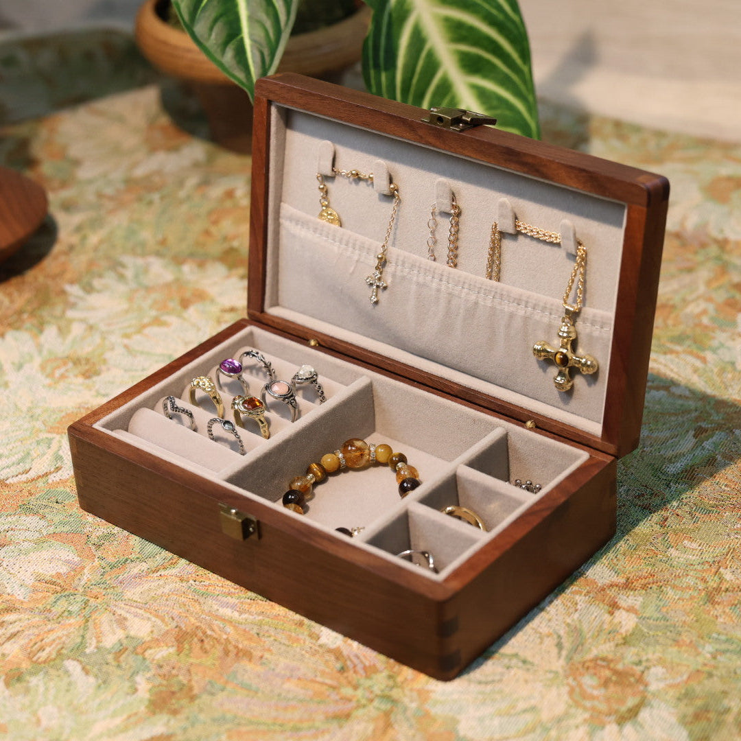 Wooden jewelry box with earrings and bracelets on a floral tablecloth
