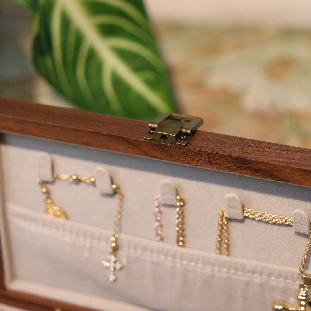 Wooden jewelry box with gold necklaces on a blurred background