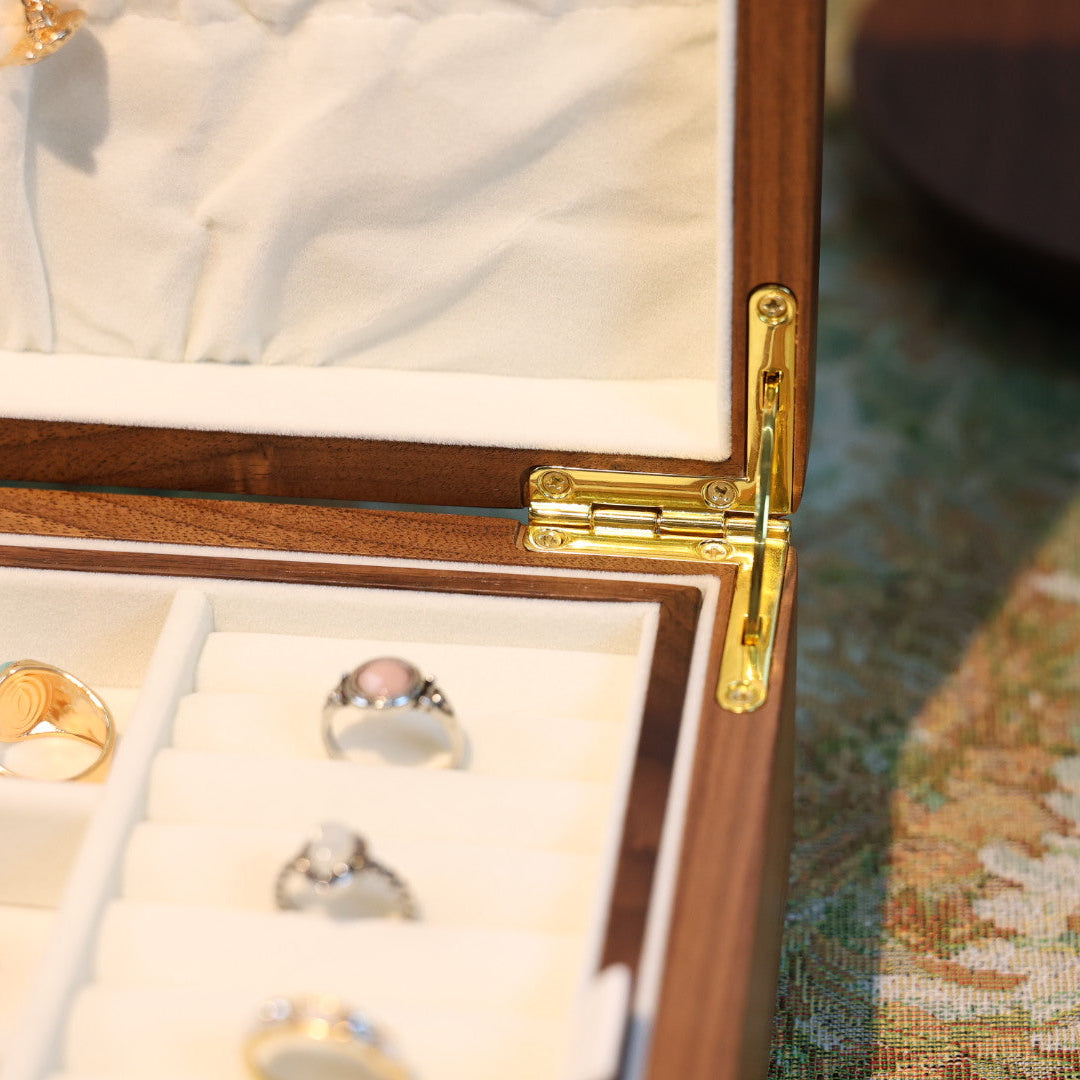 Jewelry box with rings and a bracelet on a patterned surface