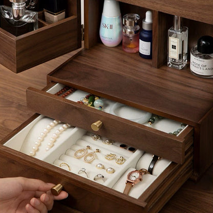 Wooden jewelry box with open drawer displaying jewelry, surrounded by skincare products.